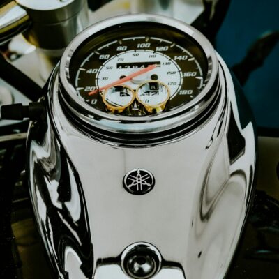 From above fancy golden wedding rings placed on contemporary powerful motorbike speedometer for proposal